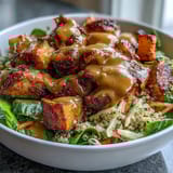 A vibrant Hot Honey Chicken Bowl topped with crunchy red cabbage slaw and tender spiced chicken pieces.