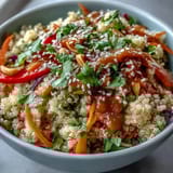 Bright Thai Coconut Quinoa Bowl topped with colorful veggies and drizzled with creamy peanut dressing.  