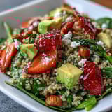 Vibrant quinoa salad bursting with ripe strawberries, buttery avocado, and fresh basil, tossed in zesty lemon vinaigrette.  
