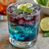 Refreshing, color-changing Butterfly Pea Flower Lemonade ready to be garnished with citrus.