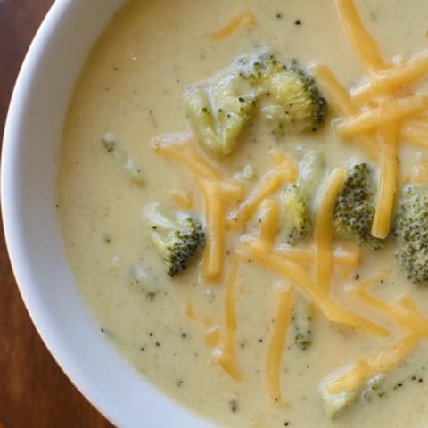 Creamy, homemade Broccoli Cheese Soup: a vibrant green soup topped with extra cheese and pepper.
