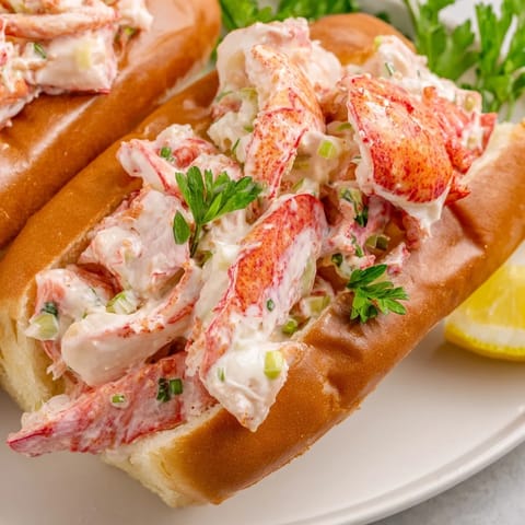 Fresh, creamy New England Lobster Roll featuring tender lobster chunks on a toasted bun.