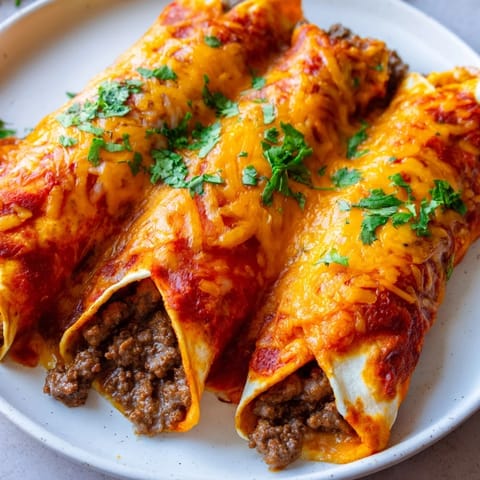 Golden, bubbling Beef Enchiladas with melted cheese and rich red sauce, ready to serve.