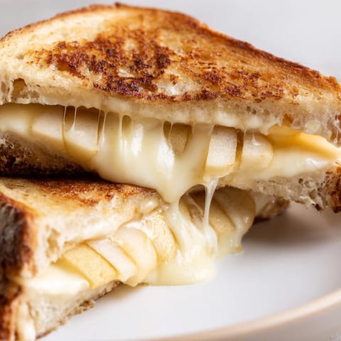 Golden-brown sourdough slices hold melted smoked Gouda and crisp apple slices for a gourmet Smoked Gouda & Apple Grilled Cheese.  