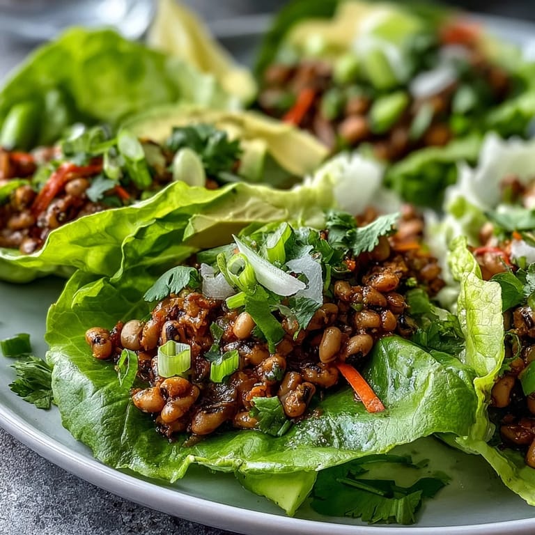 Colorful Black-Eyed Pea Lettuce Wraps plated with crunchy vegetables, herbs, and a squeeze of lemon for brightness.