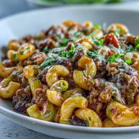 Steaming One-Pan High Protein Chili Mac in a Dutch oven, loaded with beef, beans, and gooey cheddar.