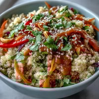 Bright Thai Coconut Quinoa Bowl topped with colorful veggies and drizzled with creamy peanut dressing.  