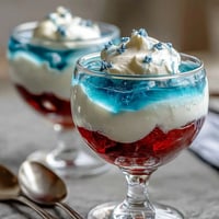 Red, white, and blue layered Jello cups with vibrant stripes, perfect for patriotic celebrations and summer parties.
